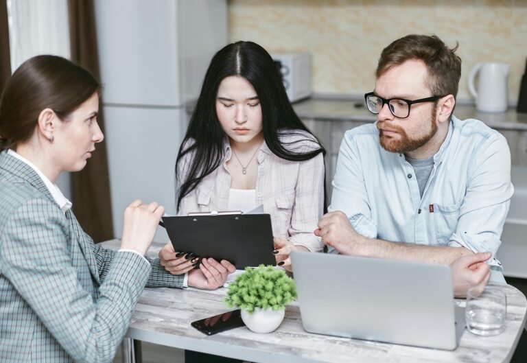 Tres personas trabajando con tablets y laptops en una oficina moderna